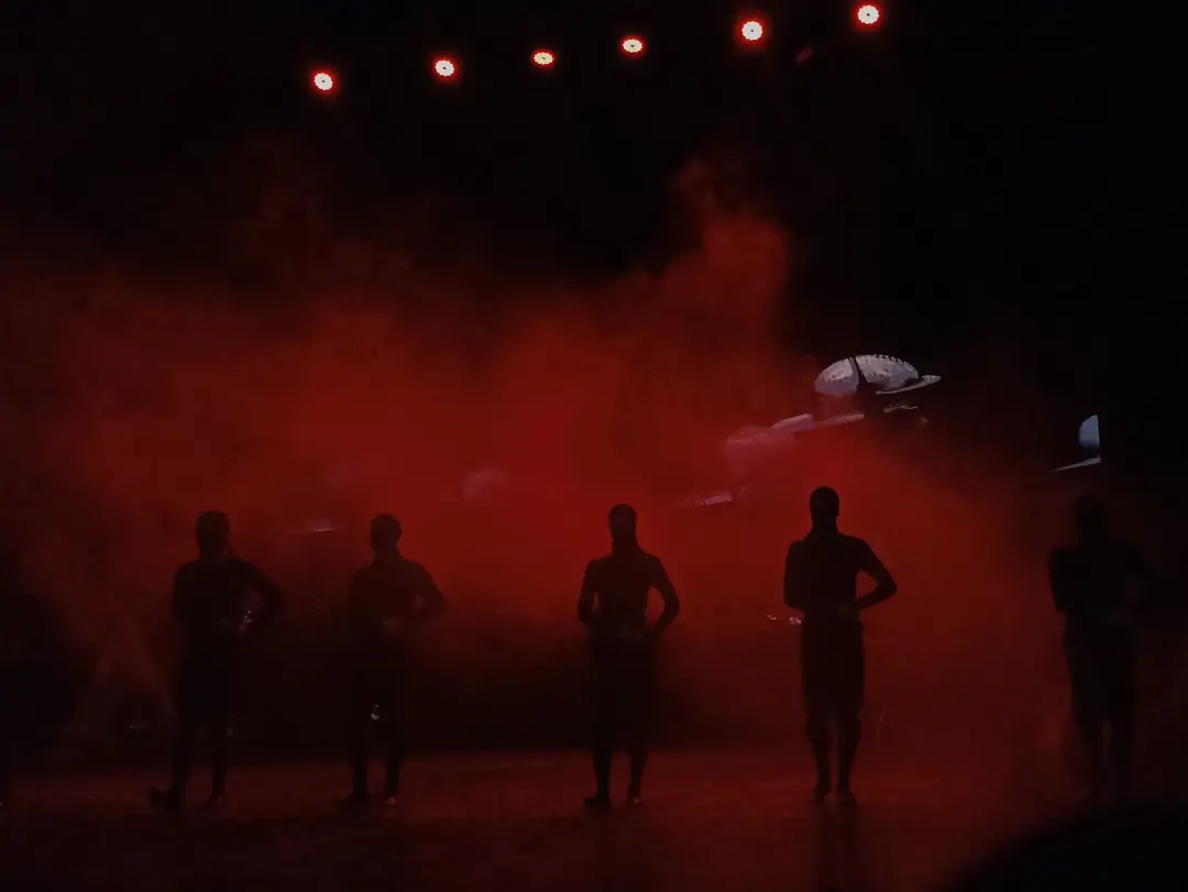 Kırmızı duman içinde sahnedeki dansçılar