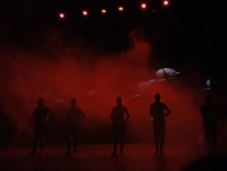 Kırmızı duman içinde sahnedeki dansçılar
